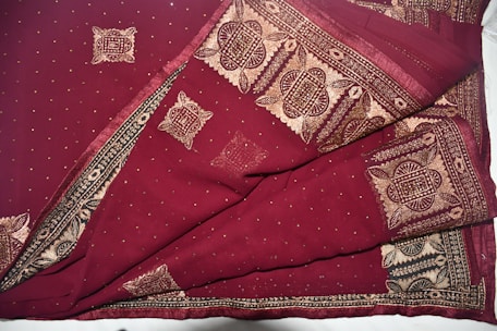 Close-up of a rich maroon Banarasi silk saree with intricate gold zari work