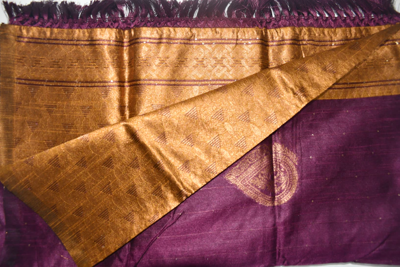 A close-up of a rich purple and gold fabric draped elegantly, symbolizing the royal theme of the Kingdom Party.