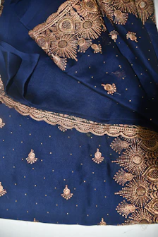 Festive embroidered suit adorned with traditional motifs in royal gold thread on charcoal fabric.