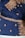 A rich blue fabric adorned with intricate gold embroidery, featuring floral and paisley patterns. The ornate designs are meticulously stitched with glittering gold thread, highlighting an elaborate and traditional textile craftsmanship.
