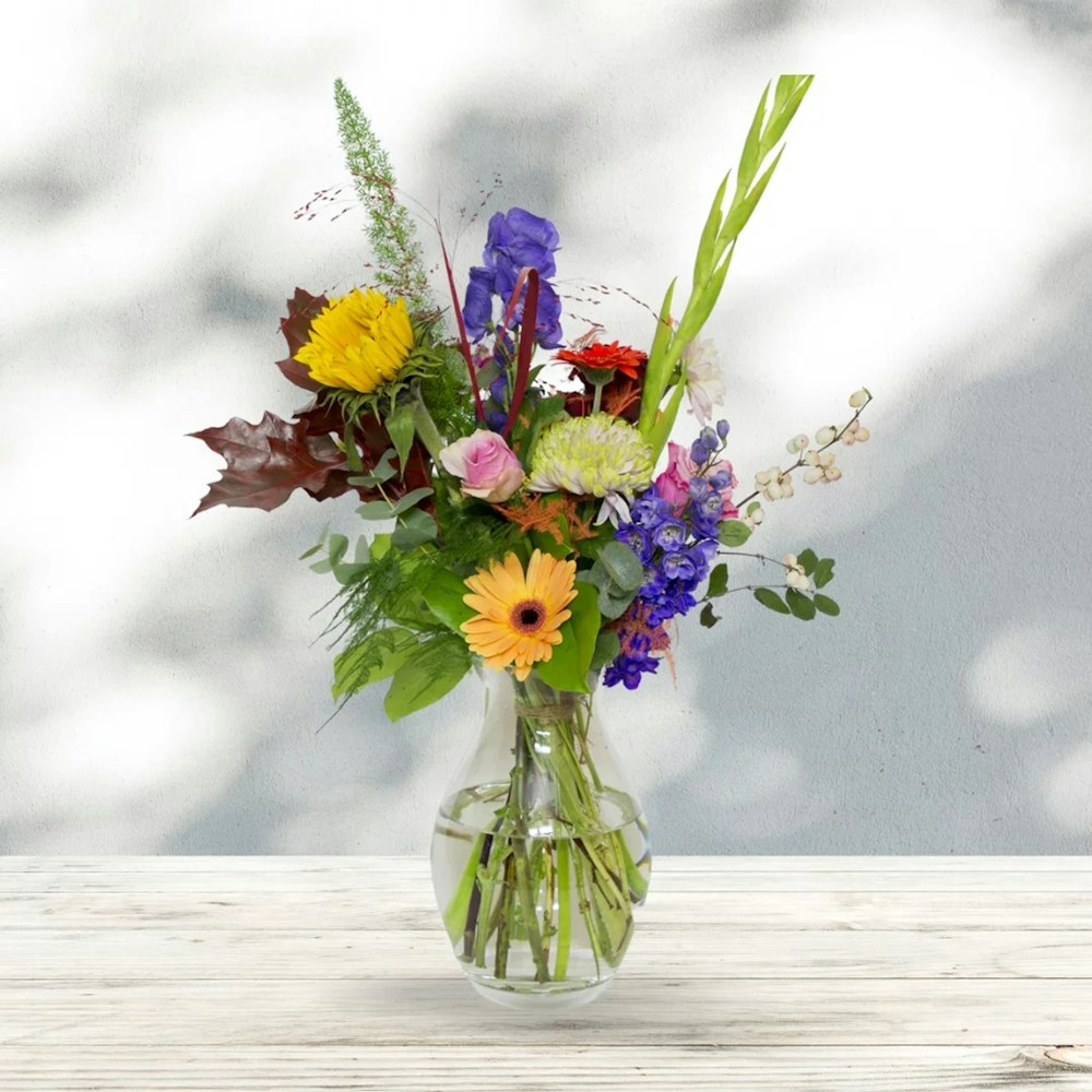 a vase filled with lots of colorful flowers