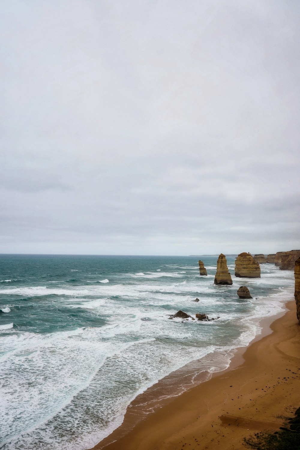 a view of the ocean and cliffs from a beach