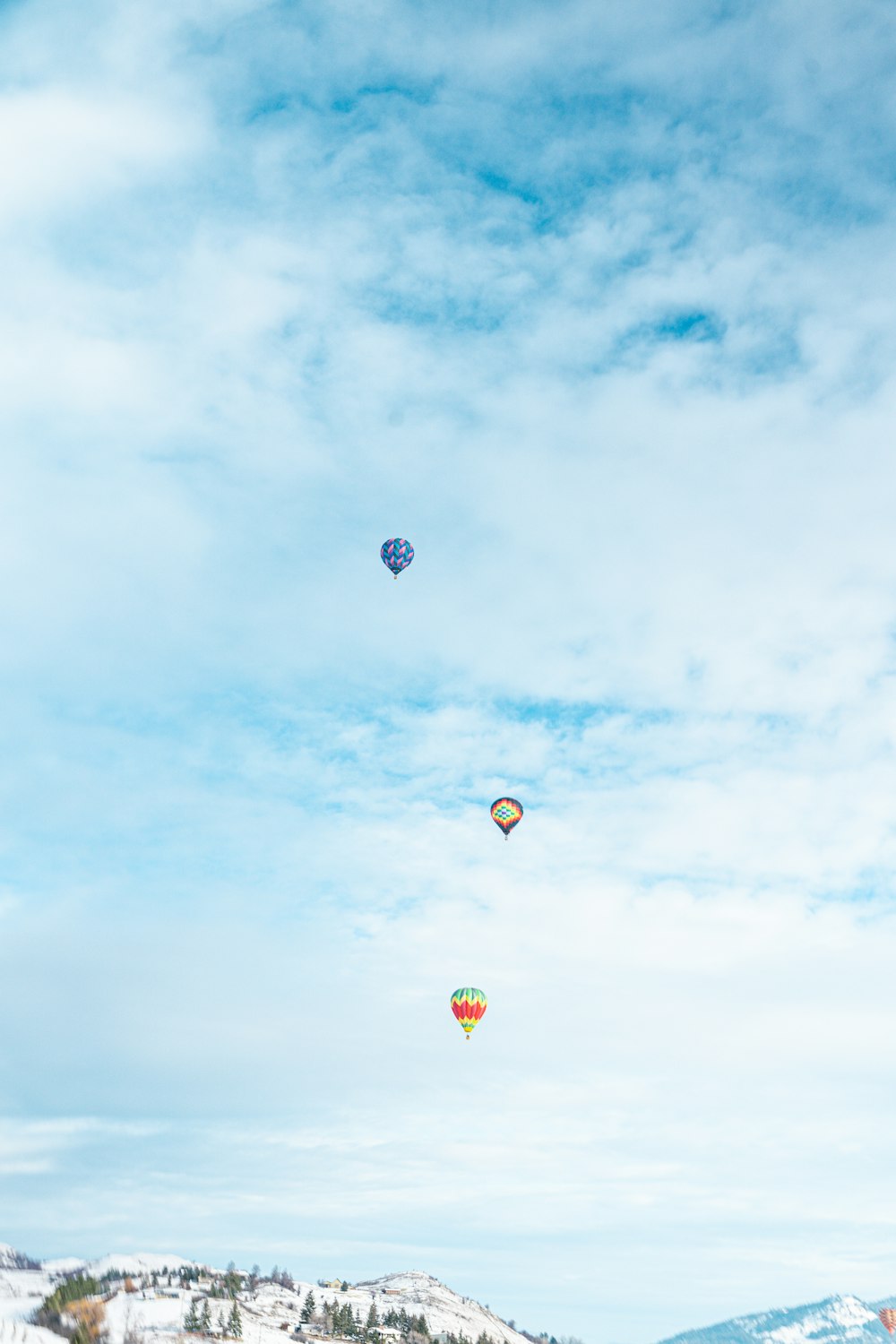 three hot air balloons flying in the sky