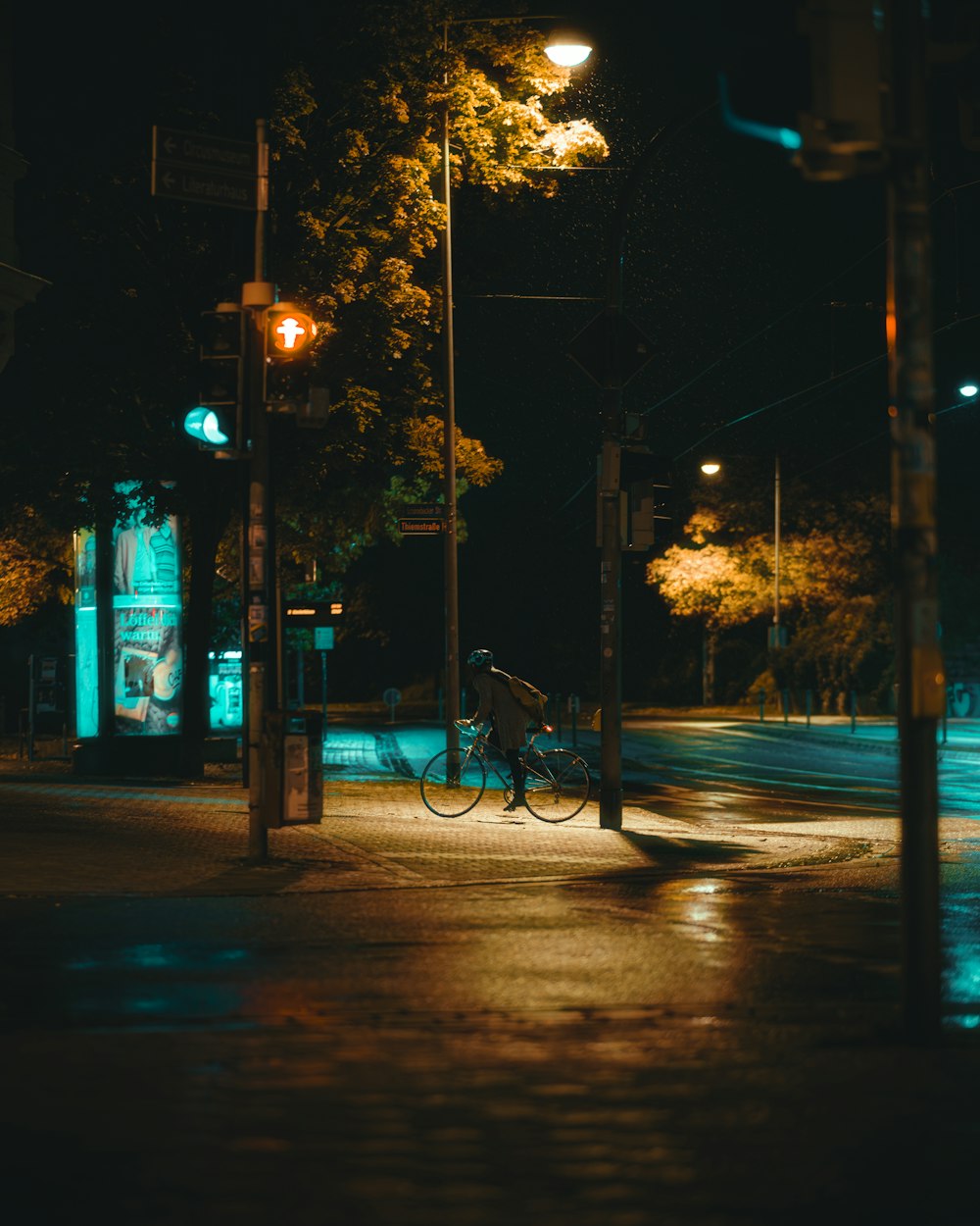 a man riding a bike down a street at night