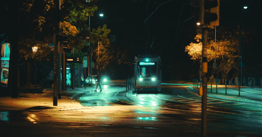 a city bus driving down a street at night