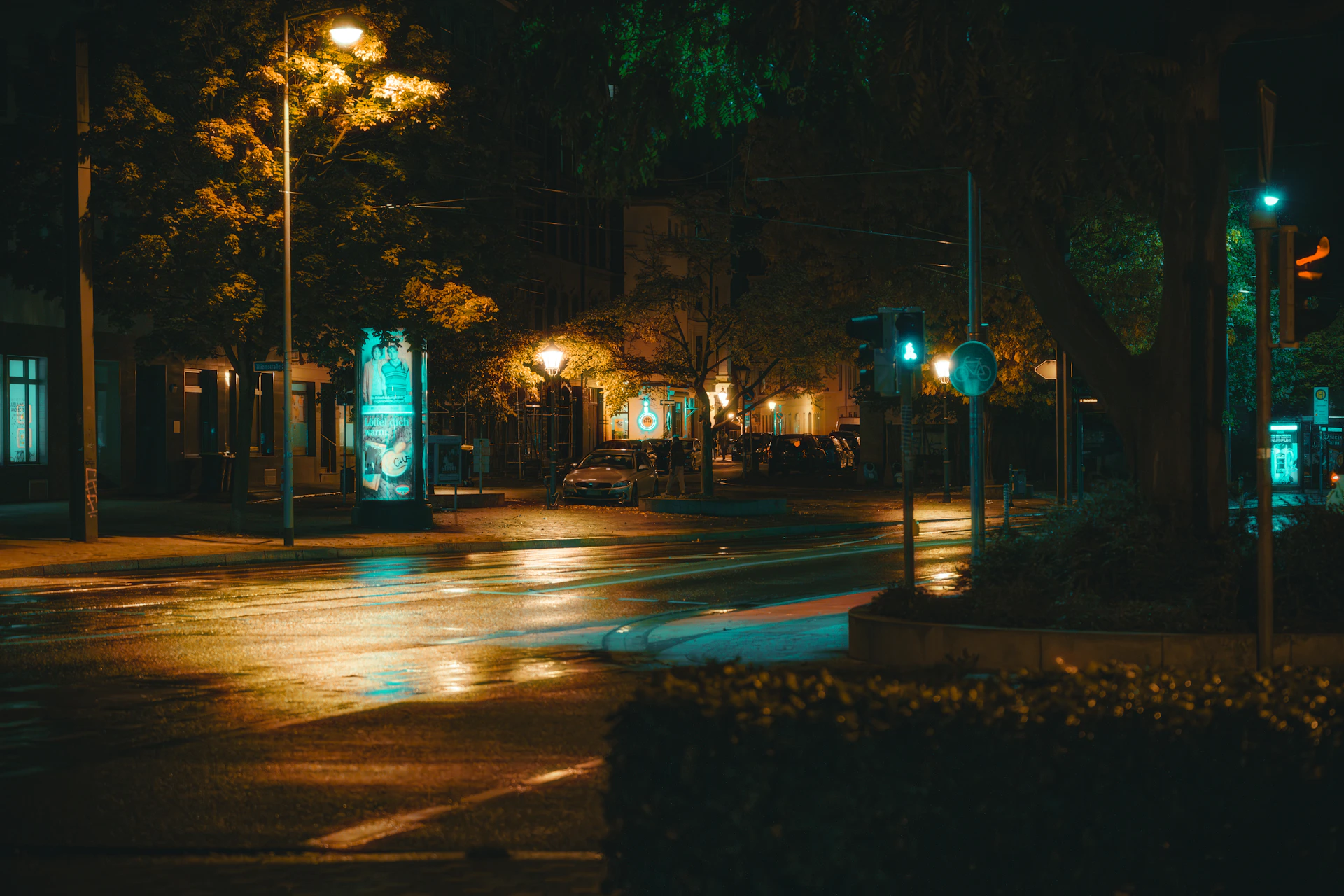 A quiet city street at twilight, the glow of street lamps reflecting on wet pavement, taken with a classic rangefinder camera.