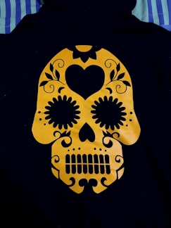 a yellow and black sugar skull on a black jacket