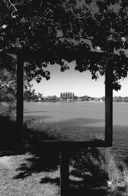 A 5x7 laser-engraved plaque nestled in a matching wooden frame, showing a detailed lake outline and personalized text.