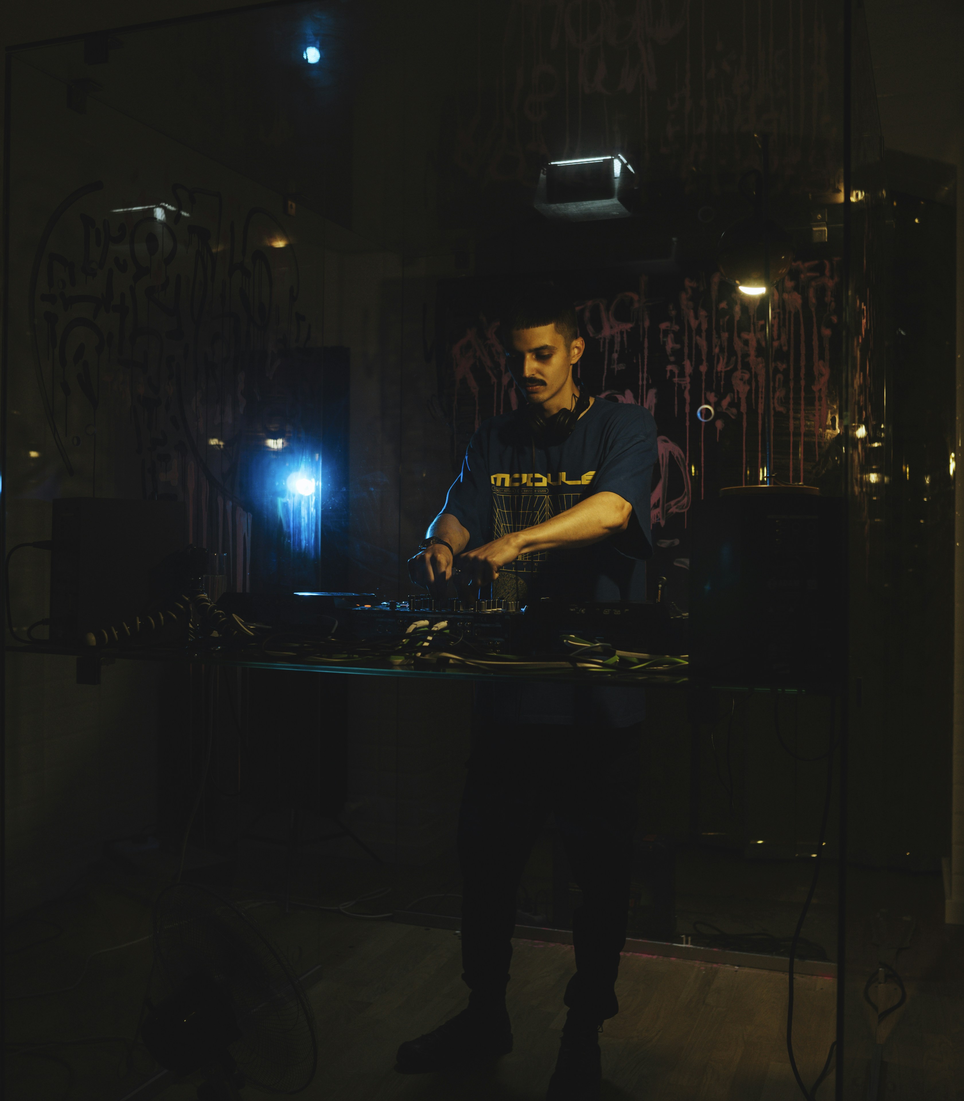 a man standing in front of a keyboard in a dark room