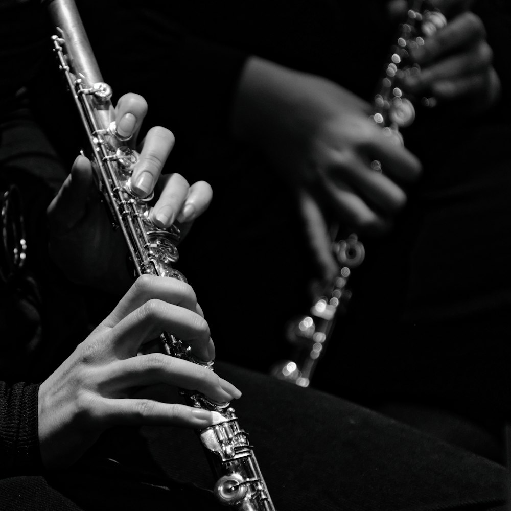 a person playing a flute in a black and white photo