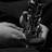 Hands holding and playing a saxophone, captured in close-up black and white photography.