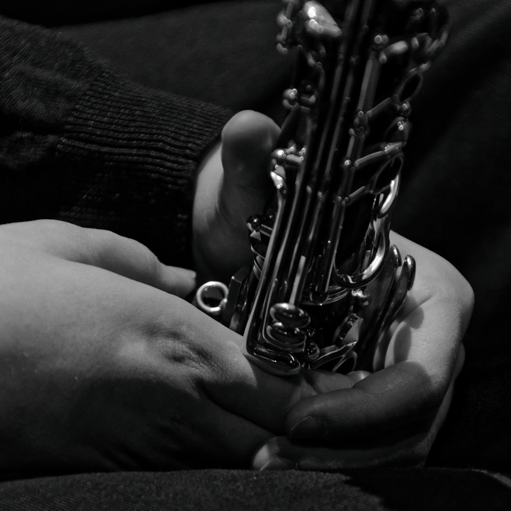 a person holding a saxophone in their hands