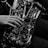 A close-up black and white photo of a person playing the saxophone, focusing on a hand pressing the keys. The instrument glistens with metallic reflections, showcasing its intricate design and craftsmanship.