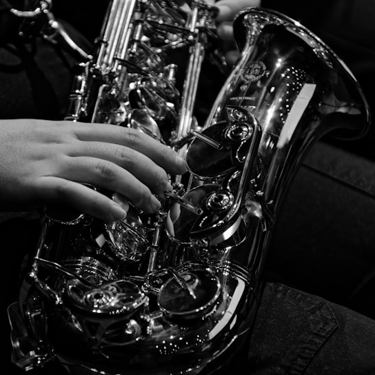A close-up of a professional musician playing a saxophone on stage.
