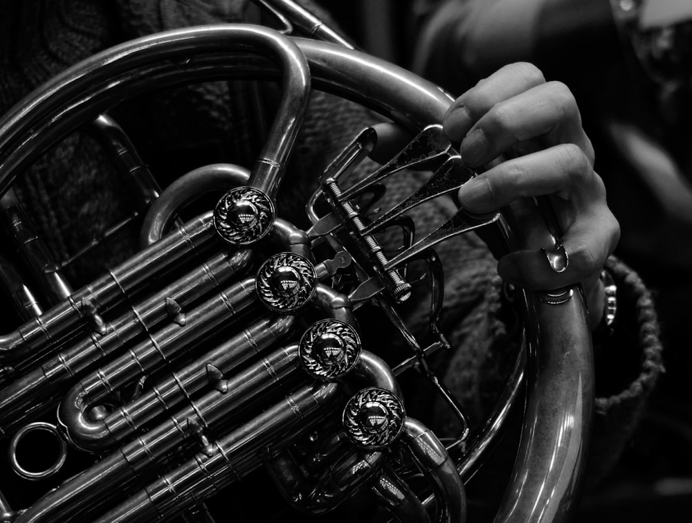 a close up of a person holding a french horn