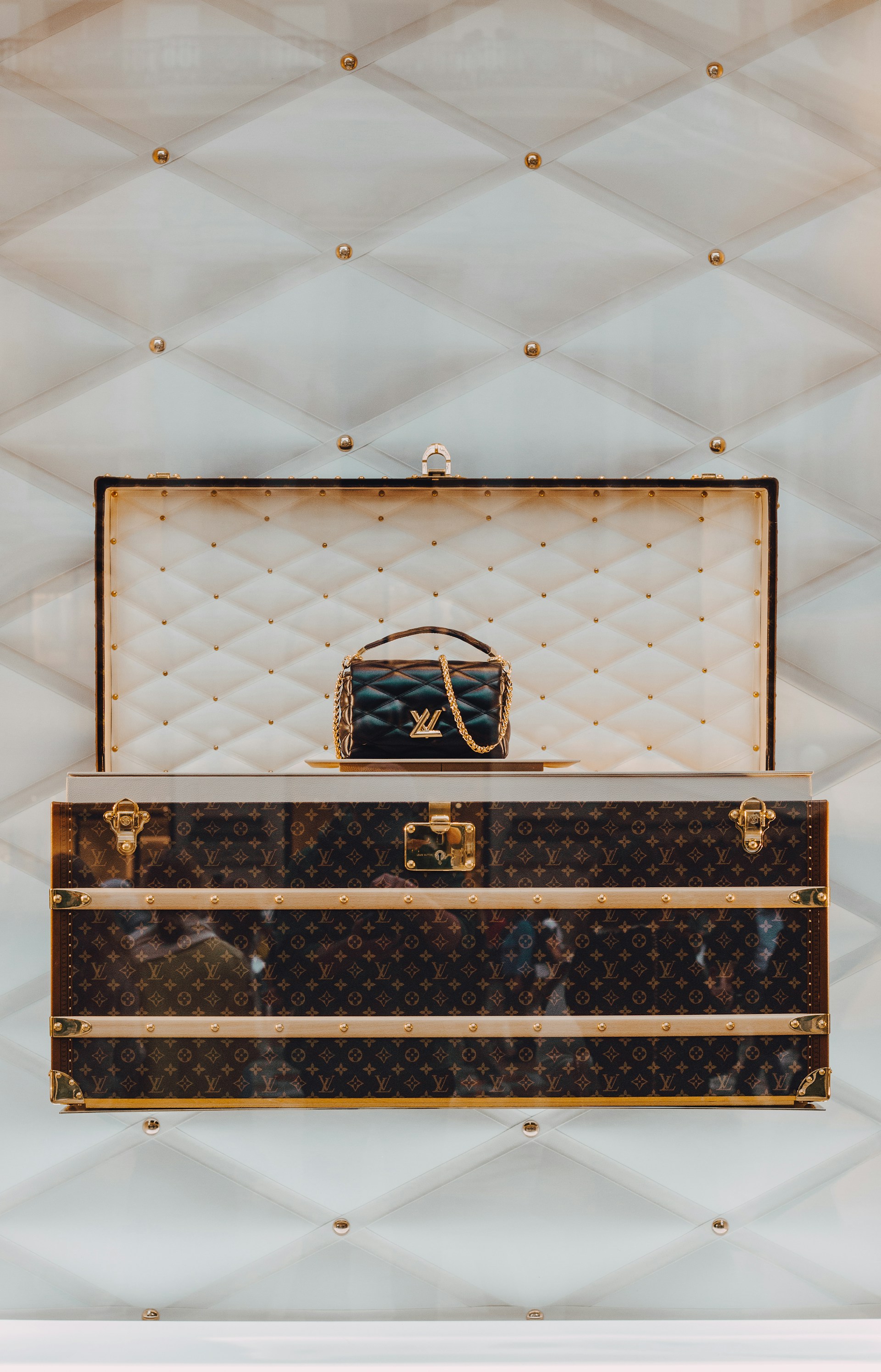 a louis vuitton trunk with a handbag on top of it