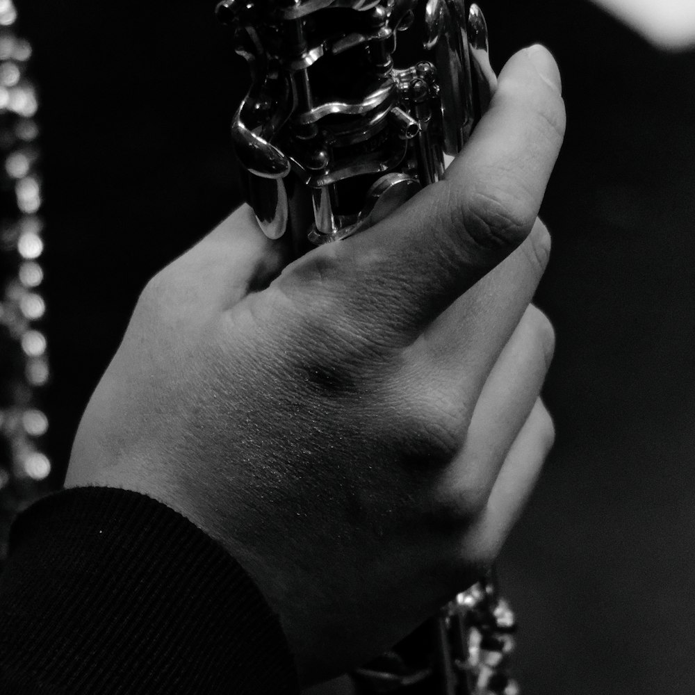 a black and white photo of a person holding a piece of jewelry