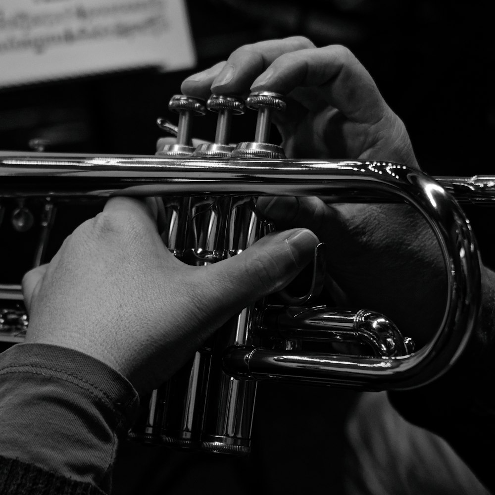 a person playing a trumpet in a black and white photo