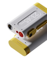 a yellow and white device with a red button