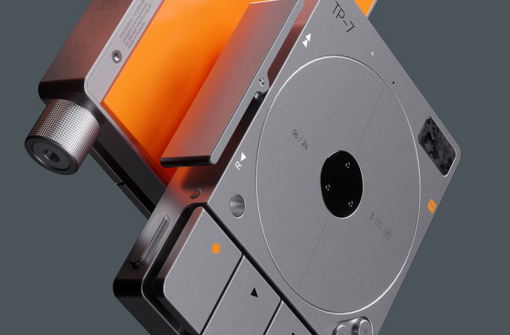 a silver and orange tape recorder sitting on top of a table