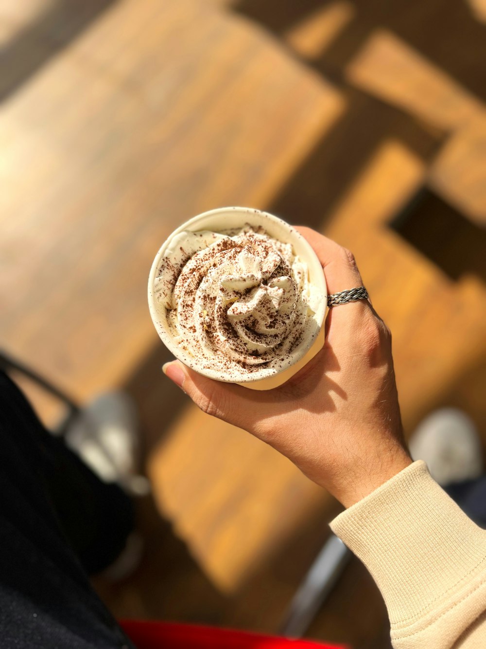 a person holding a cup of coffee in their hand