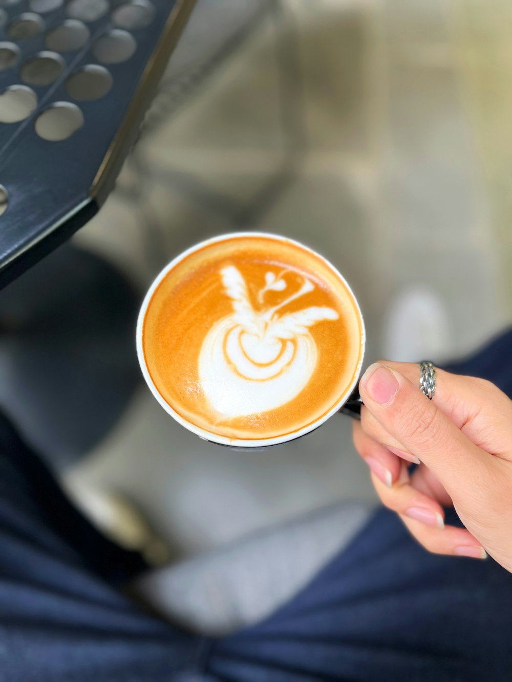 eine Person, die eine Tasse Kaffee in der Hand hält