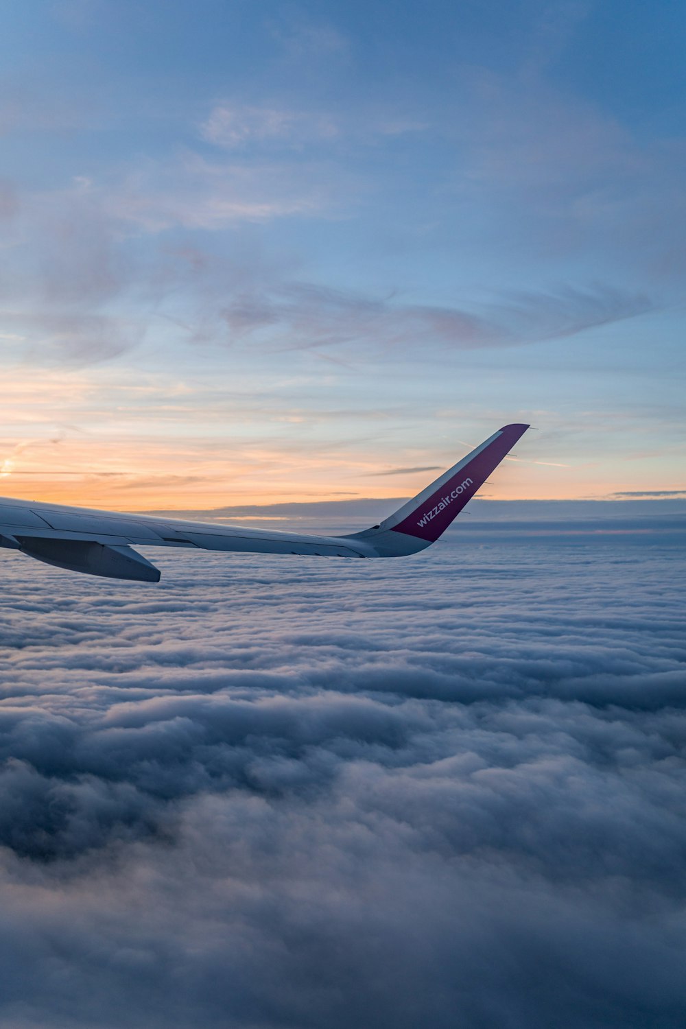 夕暮れ時に雲の上を飛ぶ飛行機