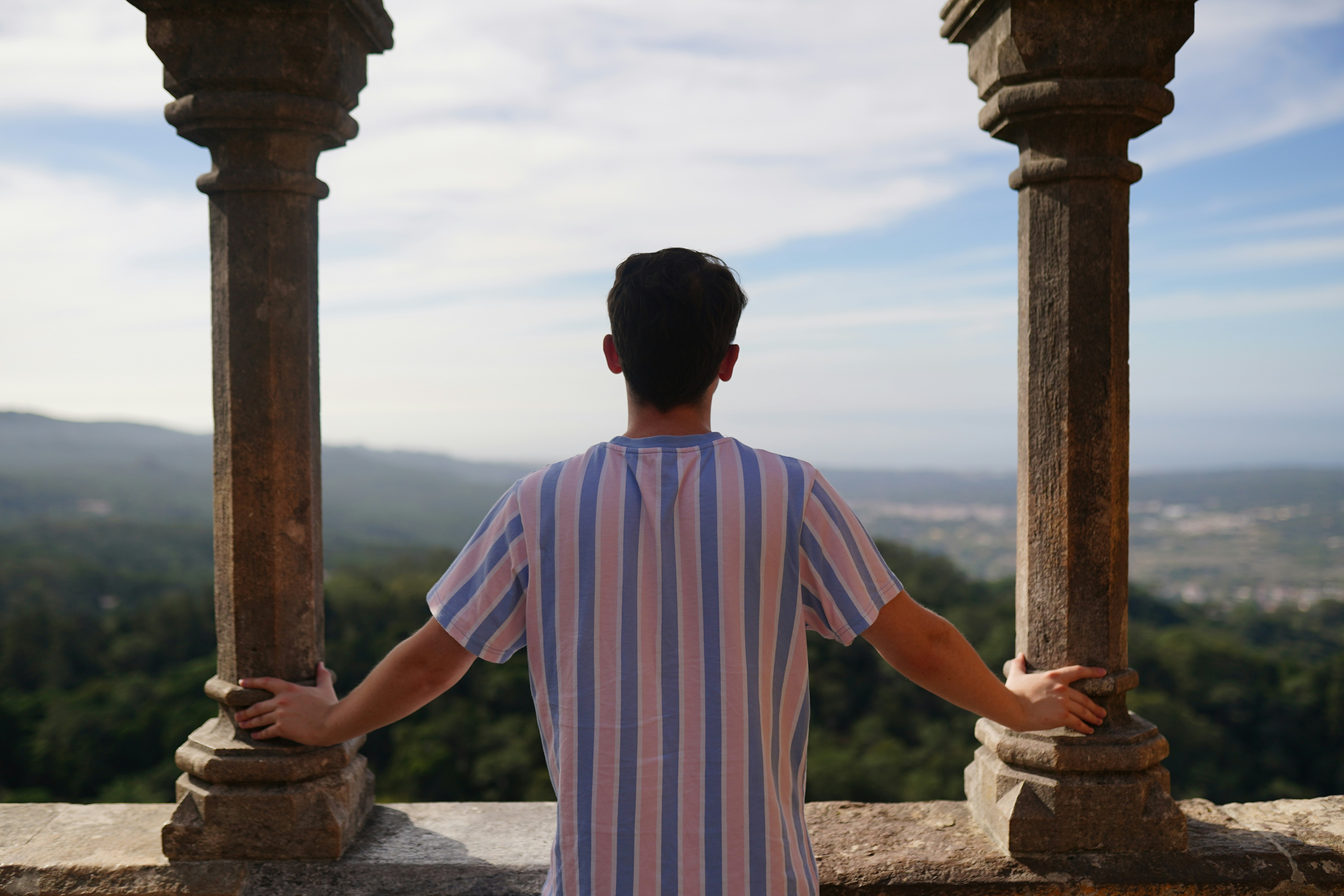 un uomo in piedi in cima a un muro di pietra