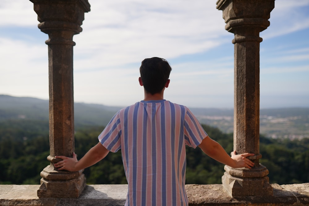 a man standing on top of a stone wall