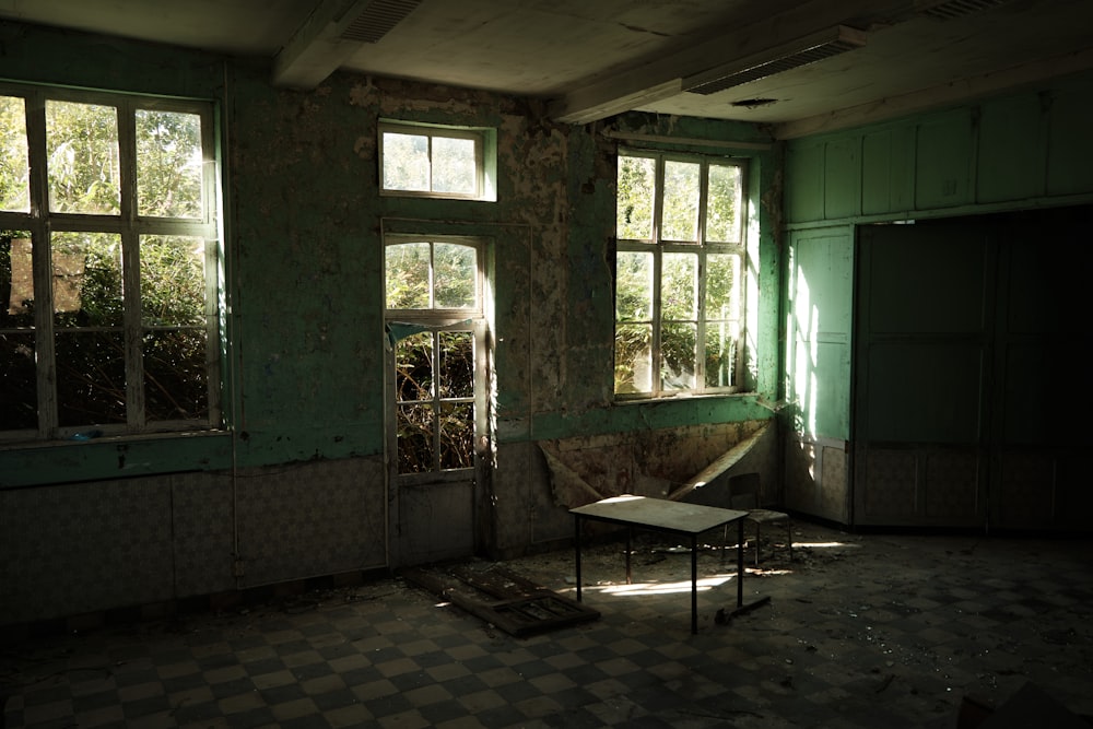 a run down room with broken windows and a broken table