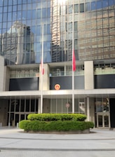 A modern campus building with international flags fluttering, symbolizing global education at Crownbridge.