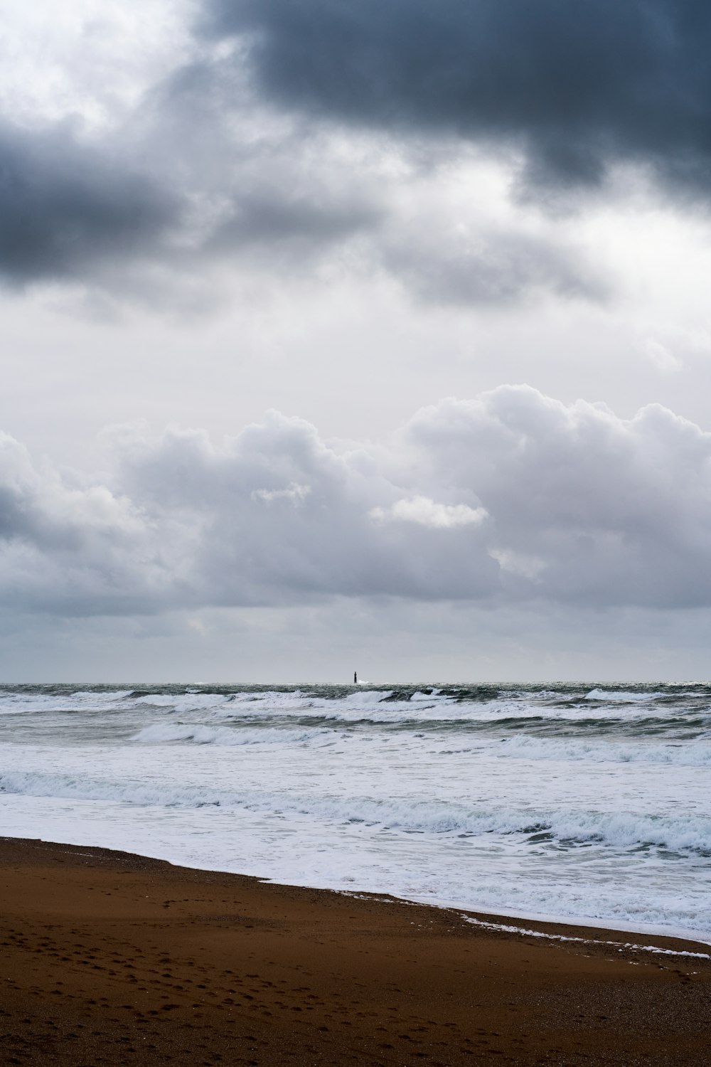 a person walking on a beach near the ocean