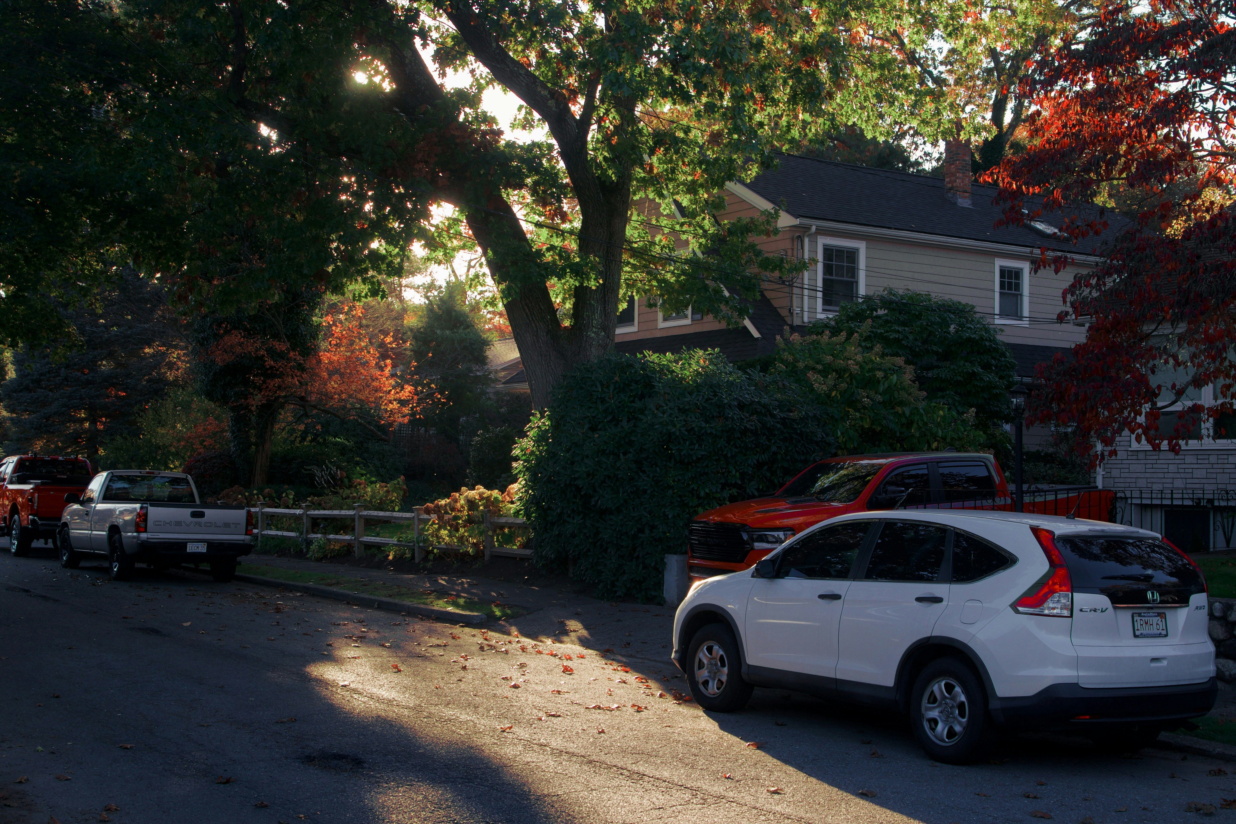 Family standing beside a used electric car parked in a suburban driveway