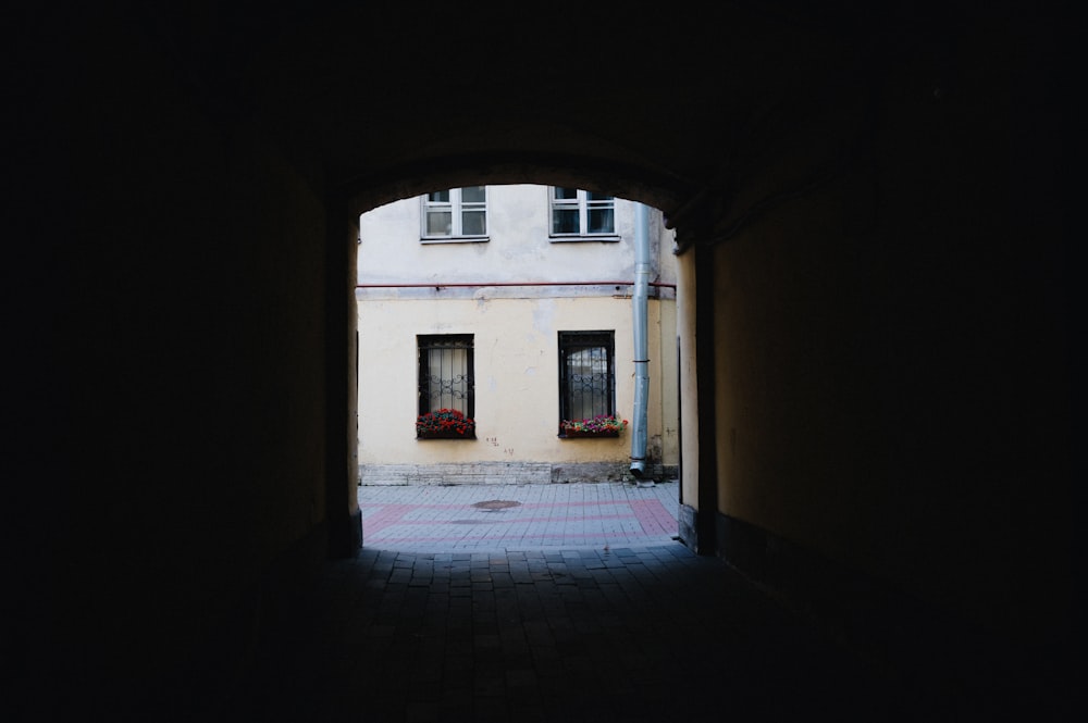 a dark alley way with a building in the background