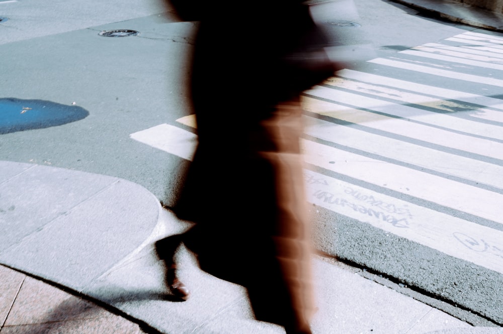 a blurry image of a person walking across a street