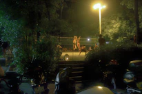 Coaches guiding young athletes during a volleyball training session under bright stadium lights.