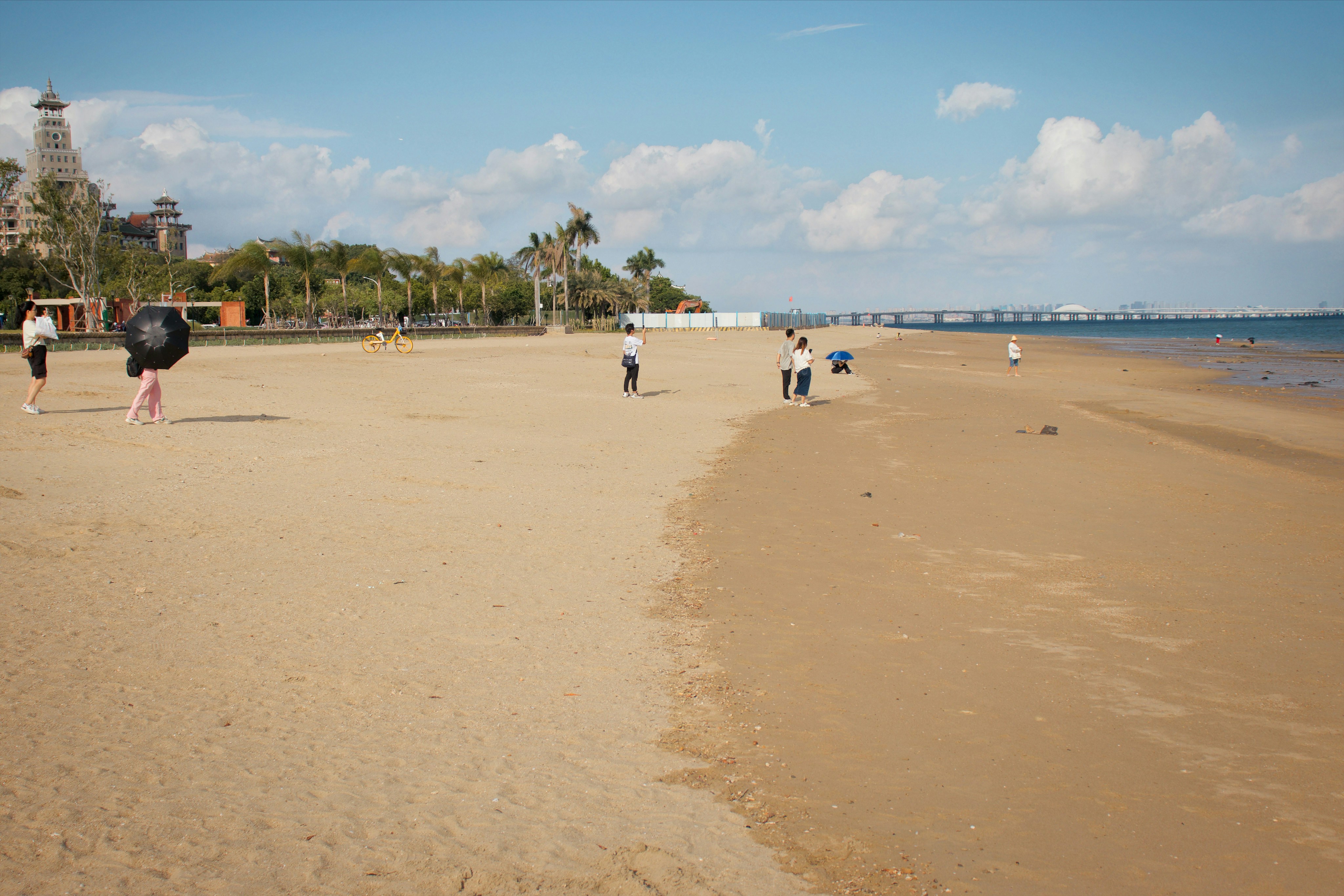 a group of people standing on top of a sandy beach