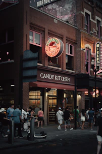 a group of people standing outside of a candy kitchen