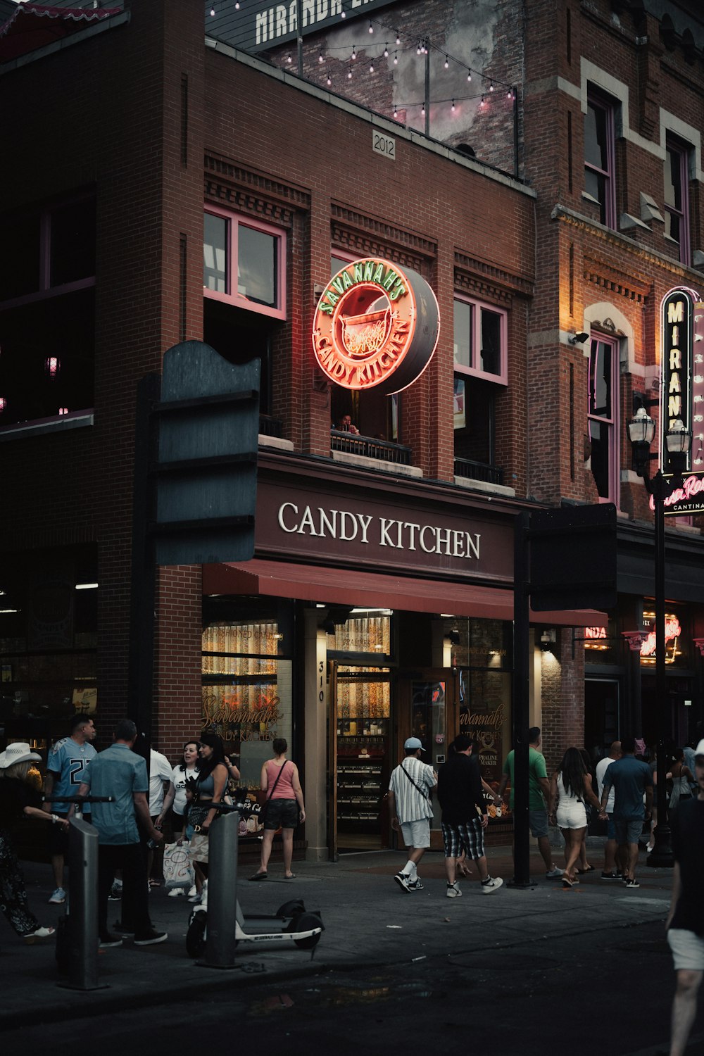a group of people standing outside of a candy kitchen