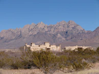 A panoramic view of the retreat’s adobe buildings nestled among cacti and rocky terrain.