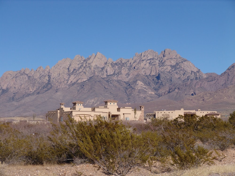 uma casa no meio de um deserto com montanhas ao fundo