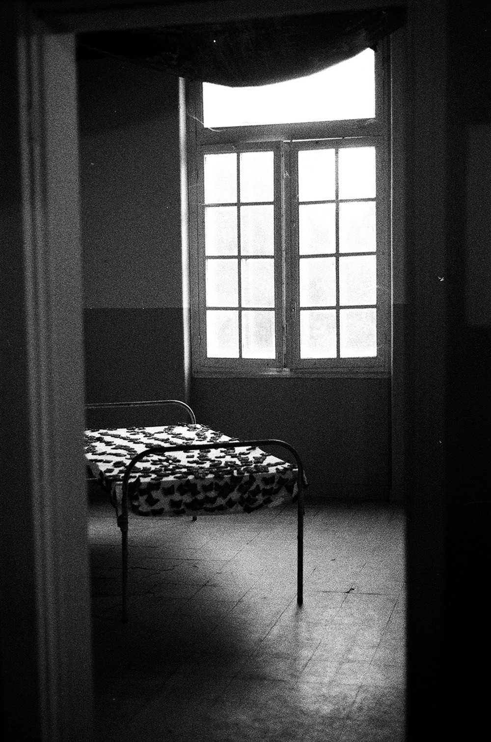 a bed sitting in a room next to a window