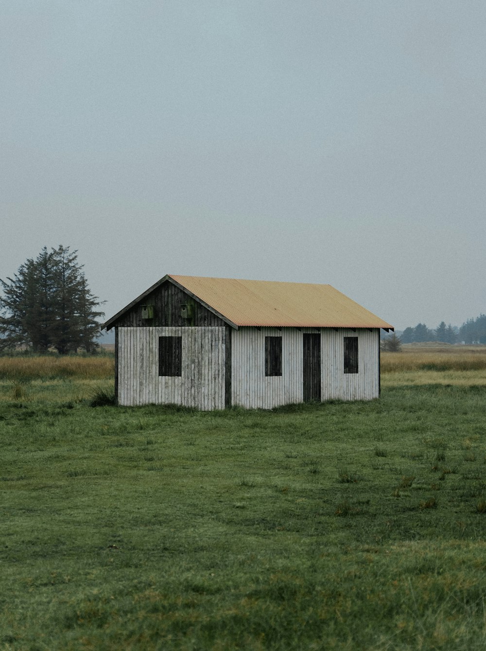 a barn in a field with trees in the background