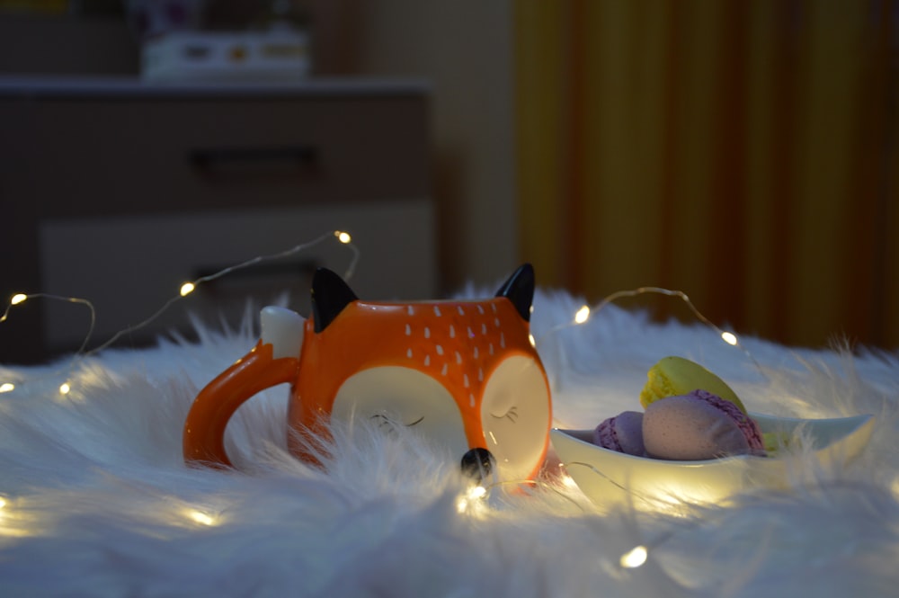 a toy fox laying on top of a white fur covered floor