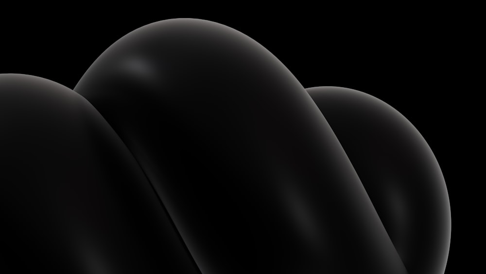 un fondo negro con tres objetos curvos