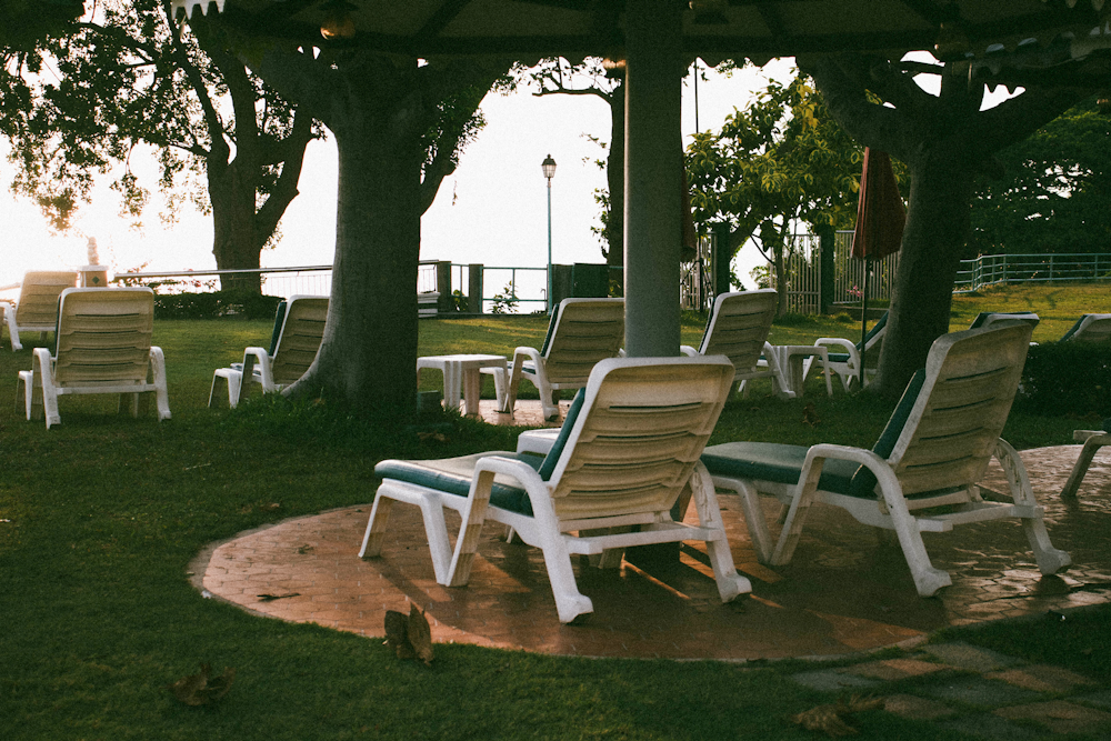 a group of lawn chairs sitting on top of a lush green field