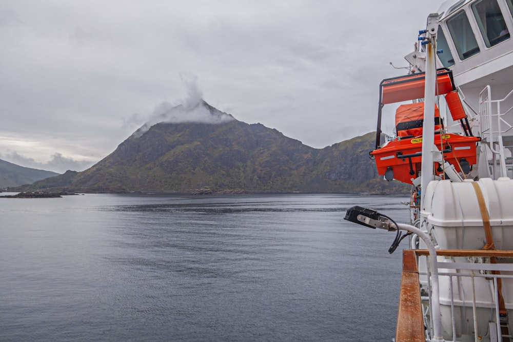 a boat on a body of water with a mountain in the background