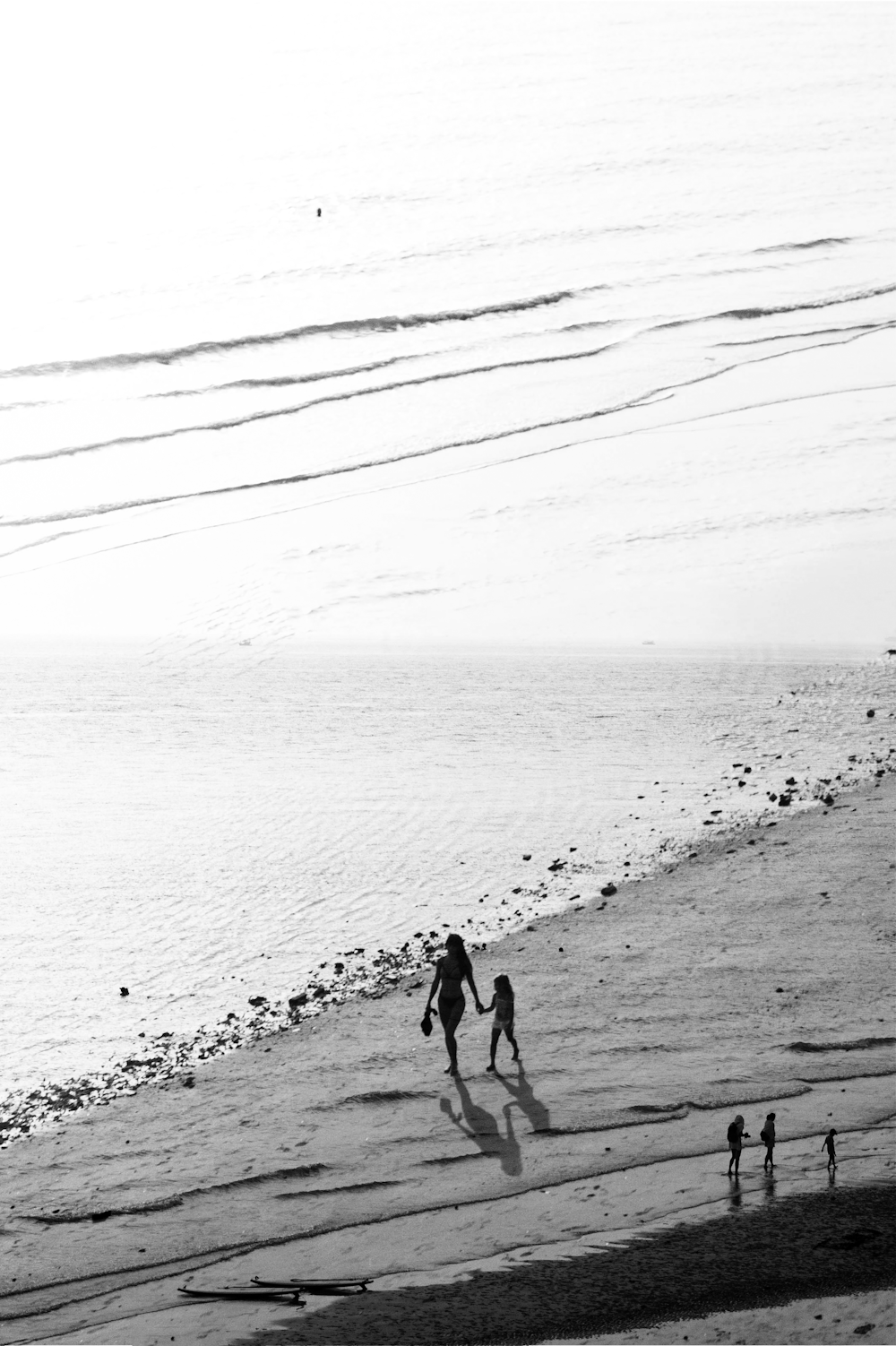 Eine Gruppe von Menschen, die an einem Strand am Meer entlang spazieren