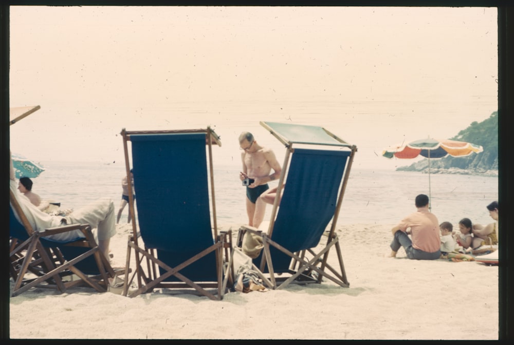 a group of people sitting on top of a sandy beach