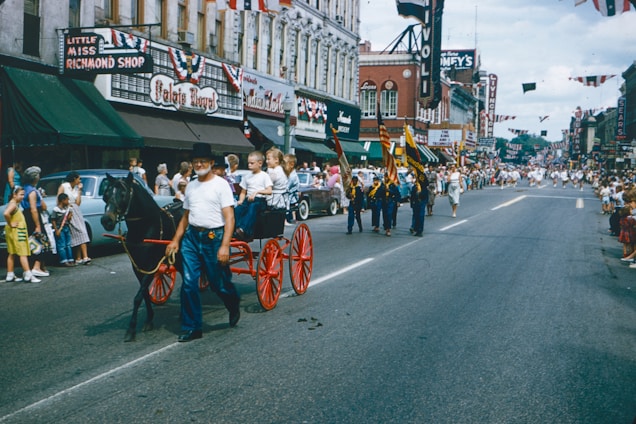 A lively parade of military bands marching through Poole with colorful flags and enthusiastic crowds.